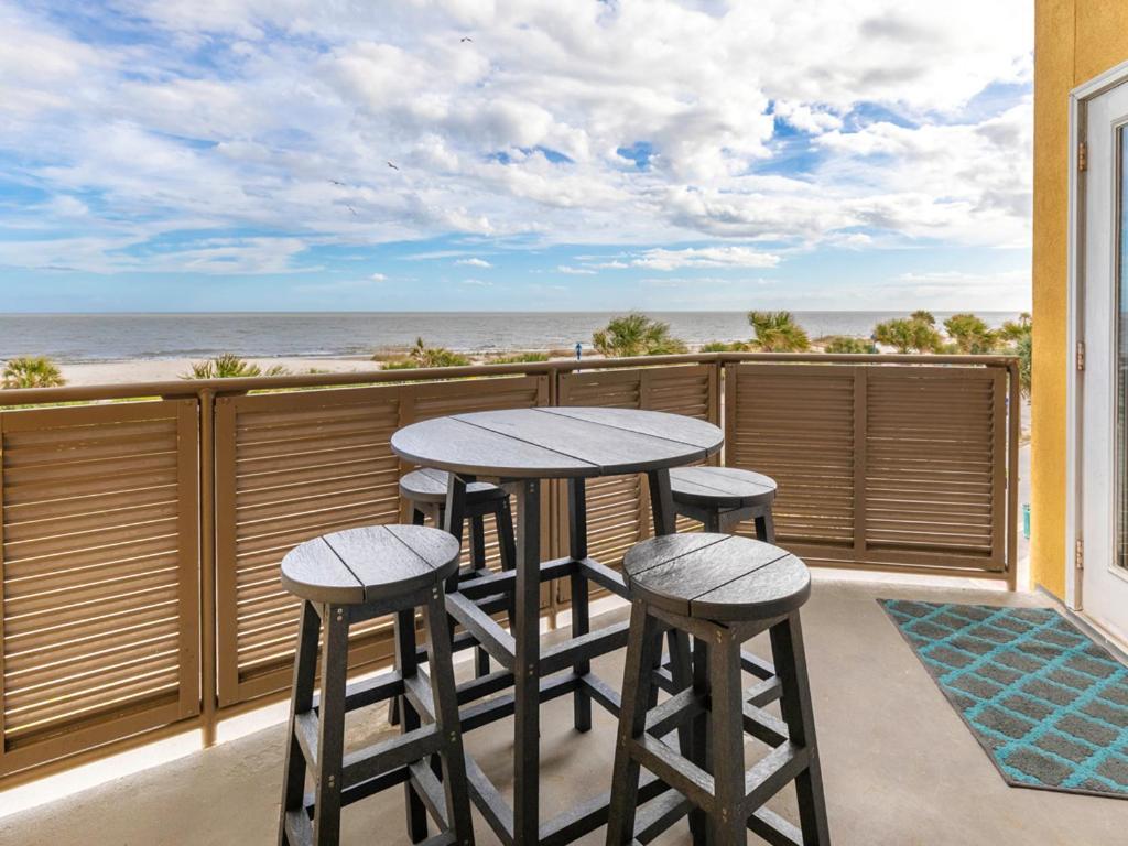 een tafel en stoelen op een balkon met uitzicht op de oceaan bij Sandpiper 205 in Tybee Island
