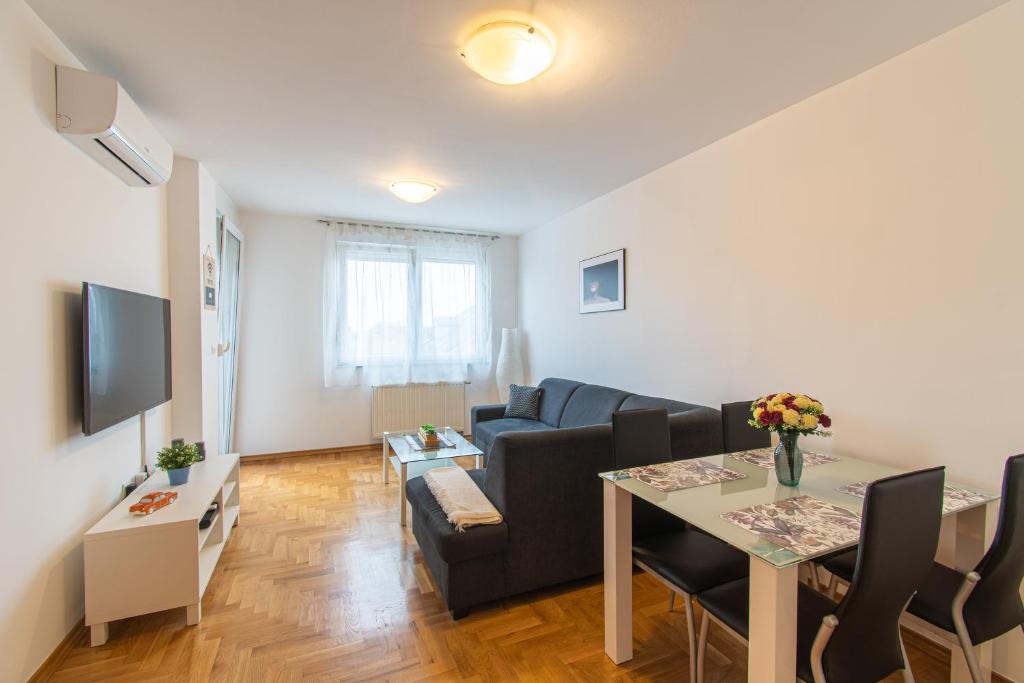 a living room with a couch and a table at Flexible SelfCheckIns 34 - Zagreb - Parking - Big Loggia - New in Zagreb