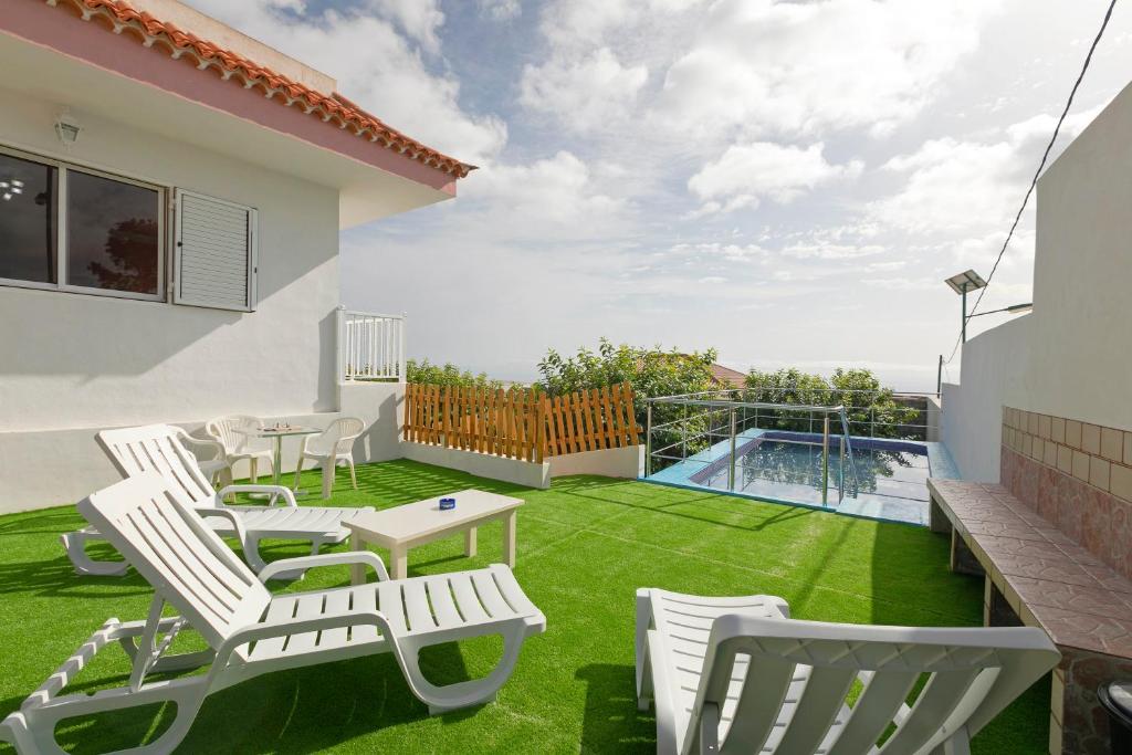 un patio con sillas de césped, una mesa y una piscina en clemente house,private pool, en Arafo