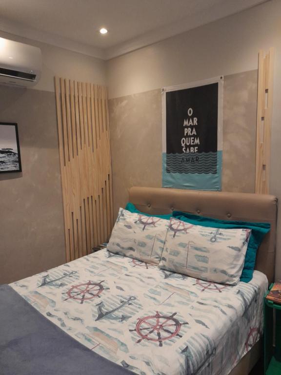 a bedroom with a bed with a sign on the wall at Estúdio Praia residence in Santos