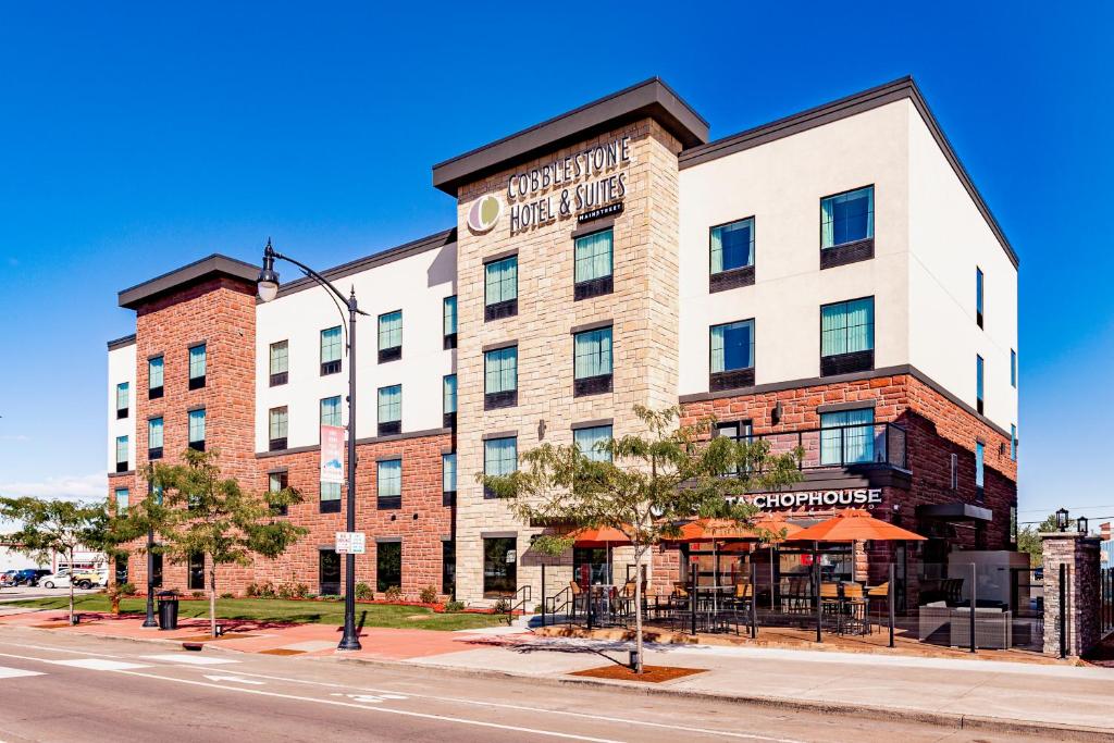 a large brick building on a street with a restaurant at Cobblestone Hotel & Suites - Superior Duluth in Superior