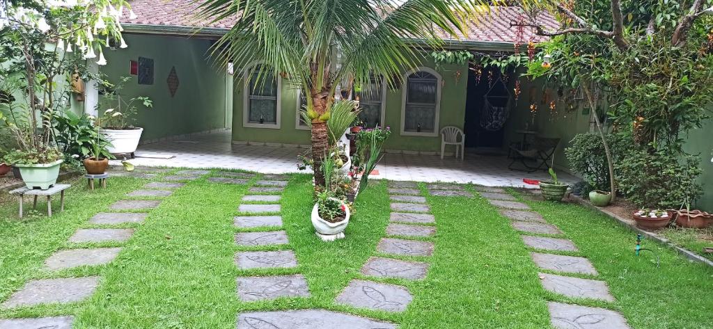 un giardino con una palma nel cortile di Casa do Aconchego, ampla, arejada com 2 vagas de garagem a Caraguatatuba