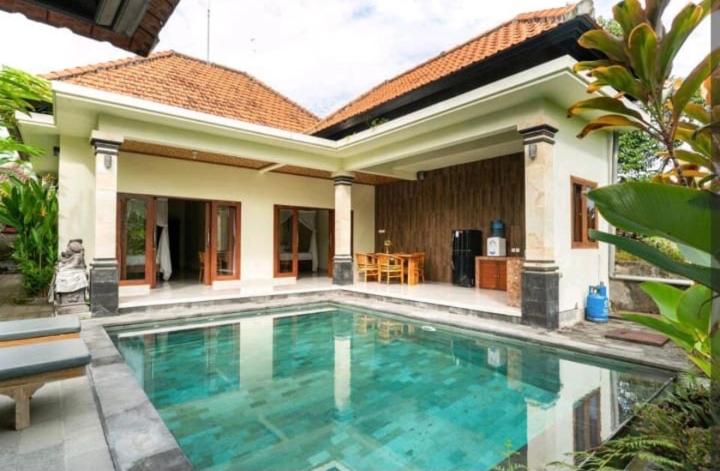 a swimming pool in front of a house at Rendira villa 2 in Ubud