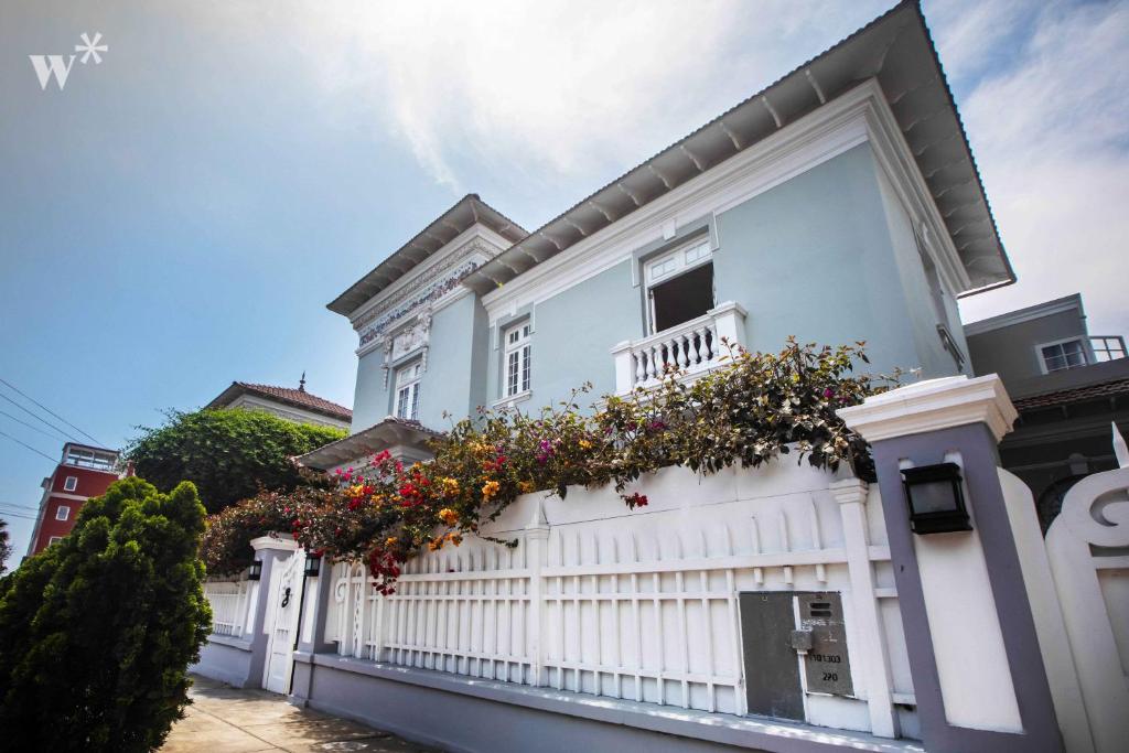una recinzione bianca con dei fiori di Casa Wynwood Barranco a Lima