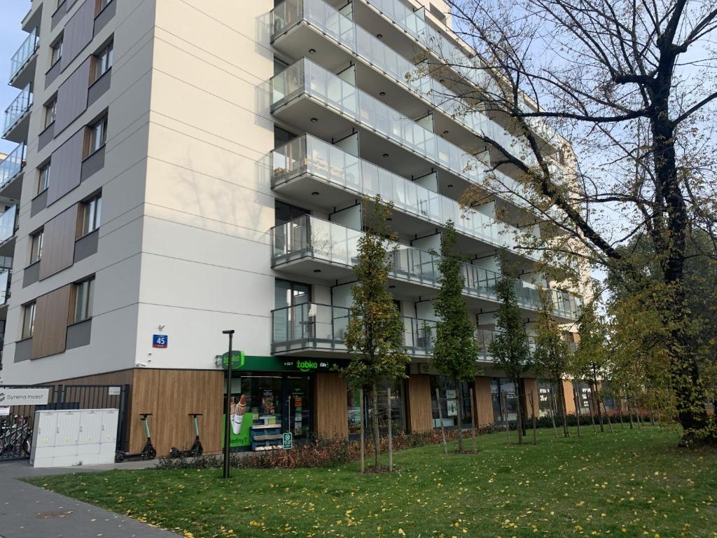 ein Apartmenthaus mit Rasen davor in der Unterkunft Mińska 45 in Warschau