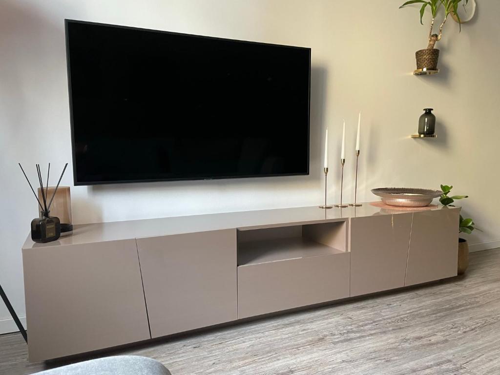 un centro de entretenimiento blanco con TV de pantalla plana en la pared en Zentrale 3-Zimmer-Wohnung in Nürnberg en Núremberg