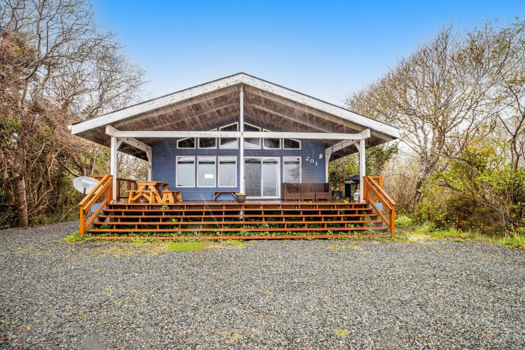a small blue house with a porch and benches at Lake Lytle Lookout in Rockaway Beach