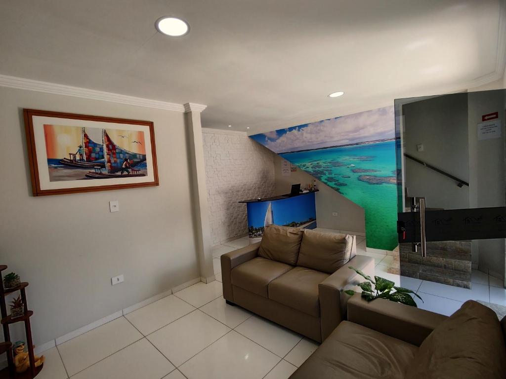 a living room with a couch and a painting of a boat at Pousada do Alemão in Maragogi