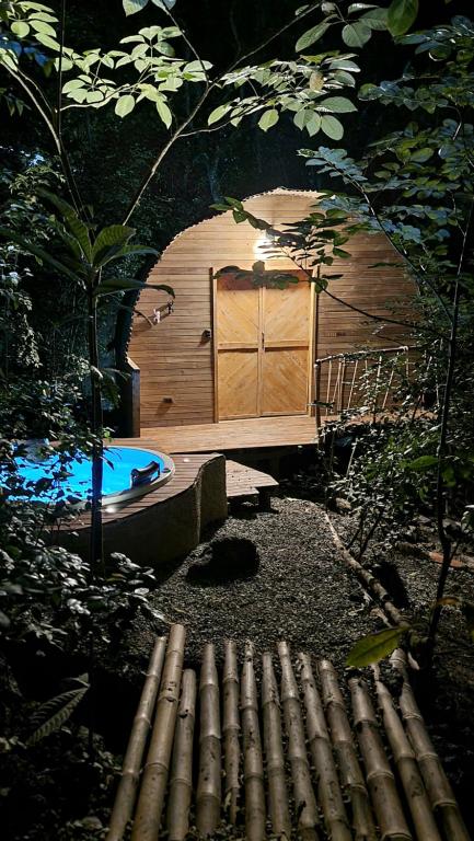 Habitación con bañera de hidromasaje y puerta de madera. en Magno Glamping en Boyacá