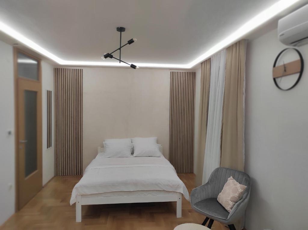 una camera con letto e sedia di Studio Apartman Lukavica a Sarajevo