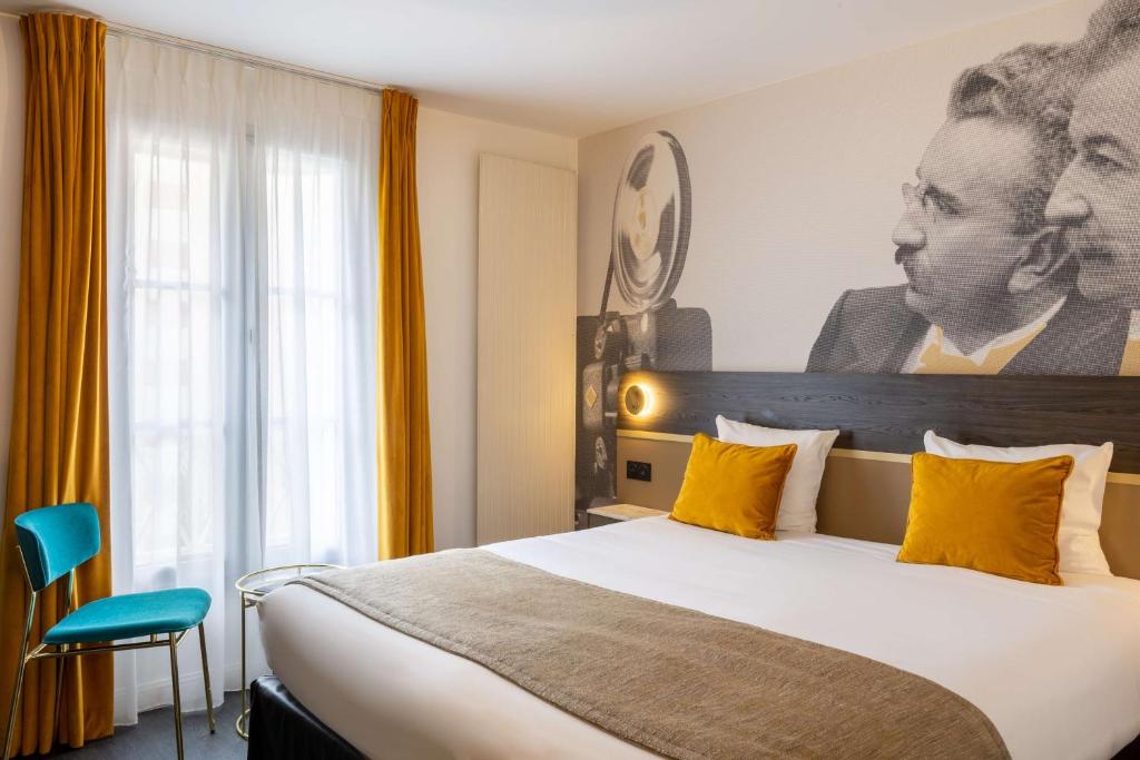 ein Hotelzimmer mit einem großen Bett mit gelben Kissen in der Unterkunft Best Western Plus l'Artist Hotel in Tours