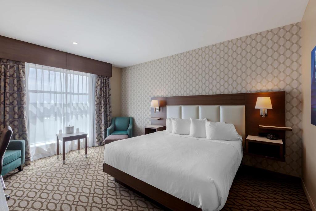 a hotel room with a large bed and a window at Best Western Plus St. John's Airport Hotel and Suites in St. John's