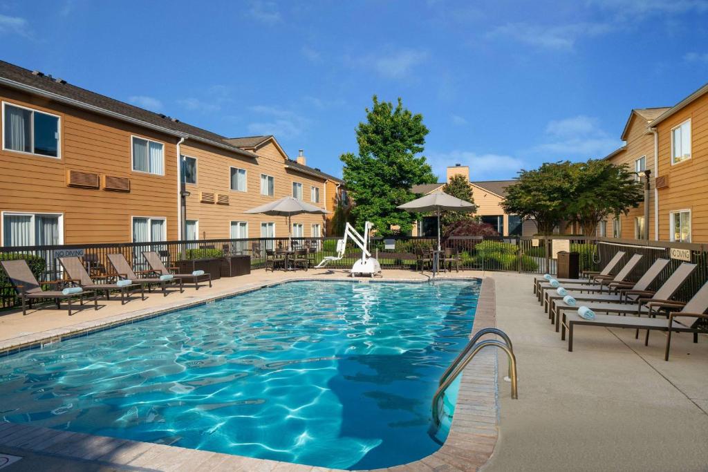 Sonesta Select Chattanooga Hamilton Place في تشاتانوغا: مسبح في فندق مع كراسي جلوس