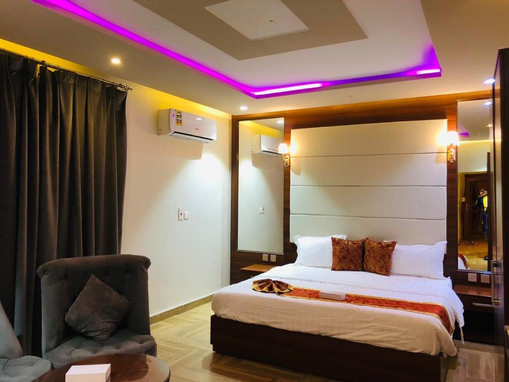 a hotel room with a bed with a purple lighting at Afaq Al Raha in Khamis Mushayt