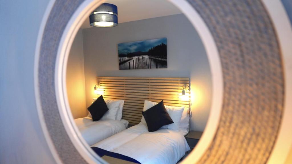 a reflection of a bedroom with two beds in a mirror at Princely House Corporate, business & family Home in Mansfield