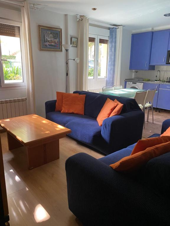 uma sala de estar com um sofá azul e uma mesa em Rio Deba Gardens em San Sebastián