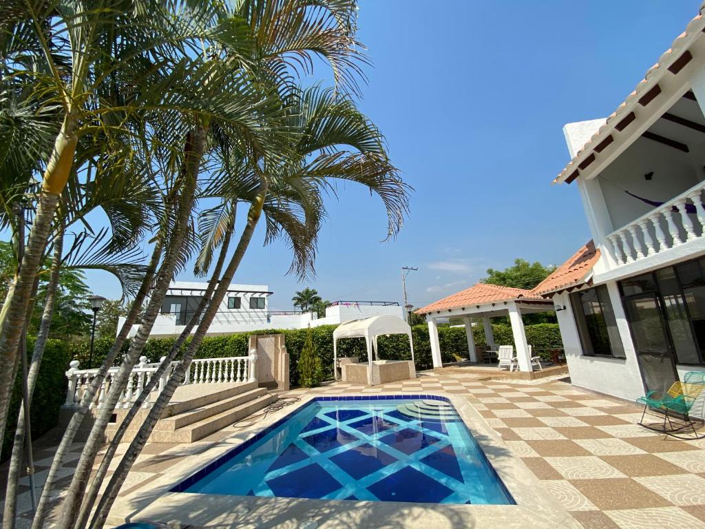 a house with a palm tree and a swimming pool at CASA ABEDULES 14 CONDOMINIO RESIDENCIAL SAN MARCOS POBLADO in Ricaurte