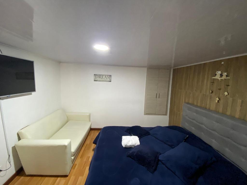 a room with a bed and a couch and a tv at Apartaestudio calido y bien ubicado en Manizales in Manizales