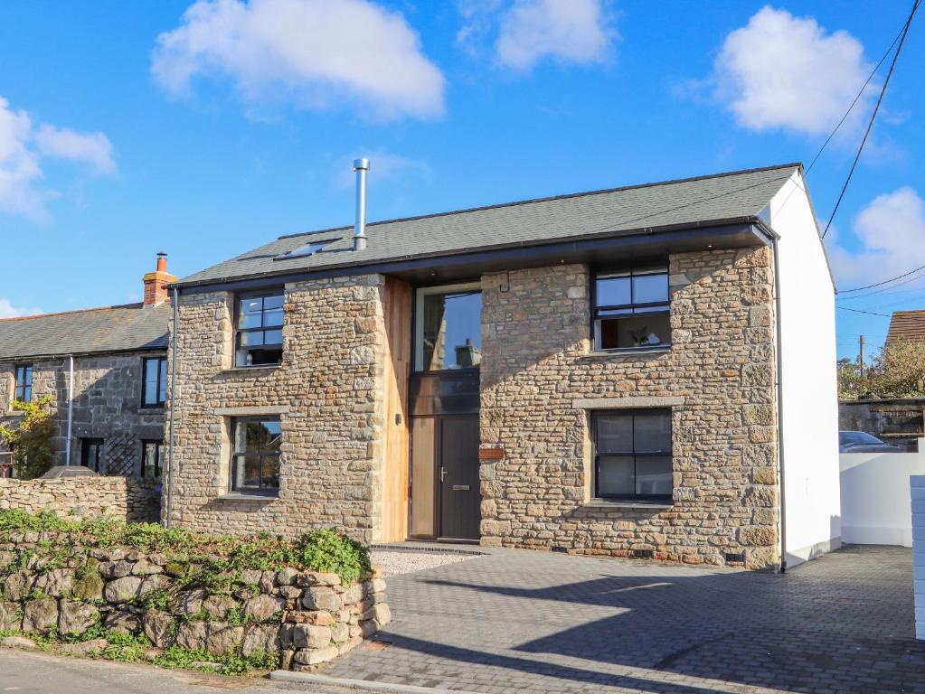 a brick house with a stone wall at Bal An Mor in Penzance