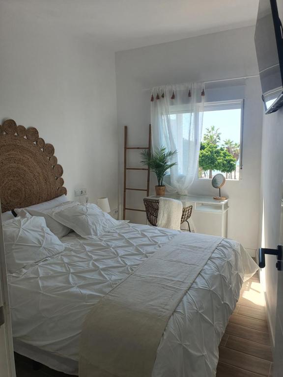 a bedroom with a large white bed and a window at Rosamar 211 Los Cristianos Ocean Views in Arona
