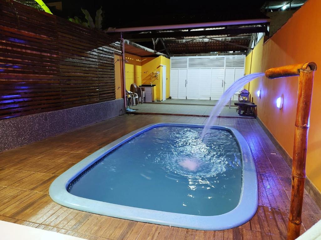 a hot tub with a water fountain in a room at Casa com piscina no centro de Maragogi pertinho da praia! in Maragogi
