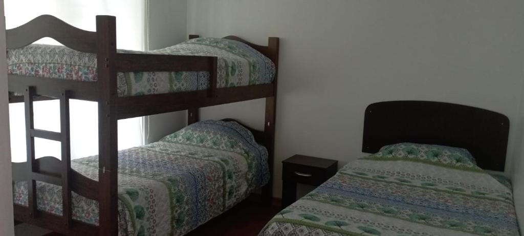 サパジャールにあるCasa Laguna de Zapallar Maitencilloのベッドルーム1室(二段ベッド2台、小型ベッド1台付)