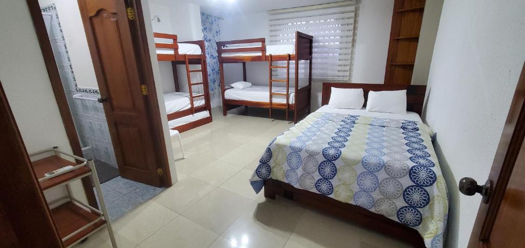 マンタにあるDepartamentos extension Casa Paraísoのベッドルーム1室(ベッド1台、二段ベッド1組付)