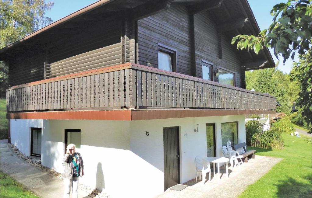 a person standing in front of a house with a balcony at Ferienhaus 7 In Thalfang in Thalfang