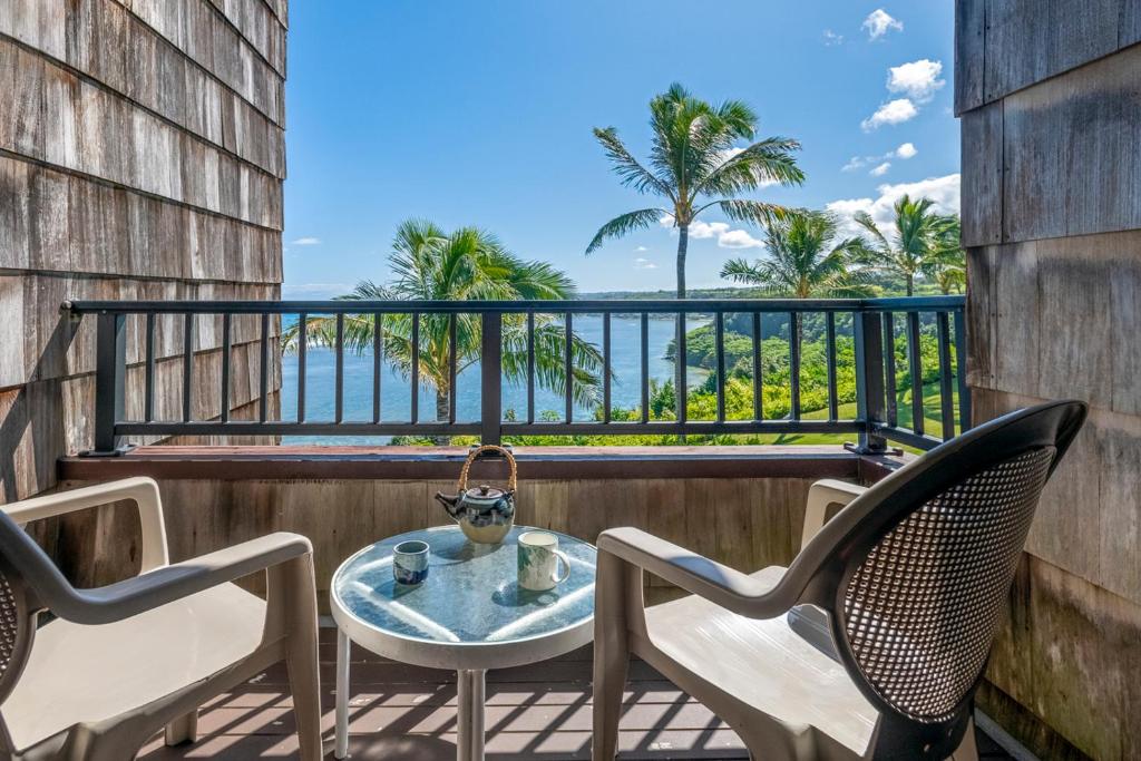 a table and chairs on a balcony with a view of the ocean at Sealodge E7 in Princeville