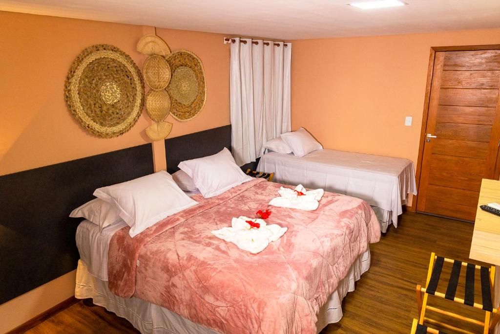 a hotel room with two beds with towels on them at Pousada Flor de Noronha in Fernando de Noronha