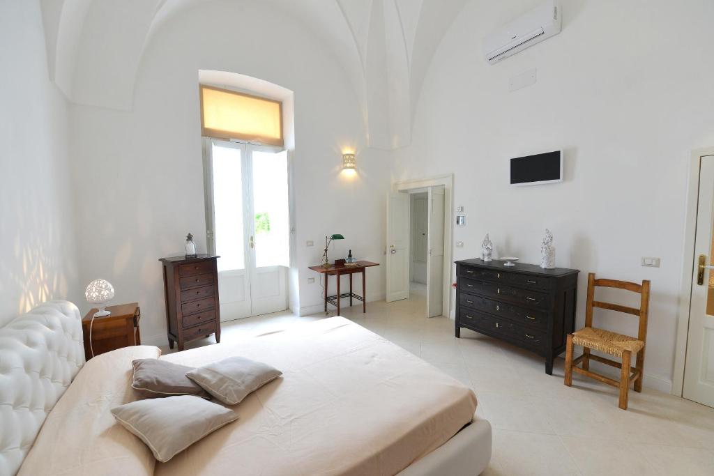 ein großes weißes Schlafzimmer mit einem Bett und einem Schreibtisch in der Unterkunft B&B Santachiara in Manduria