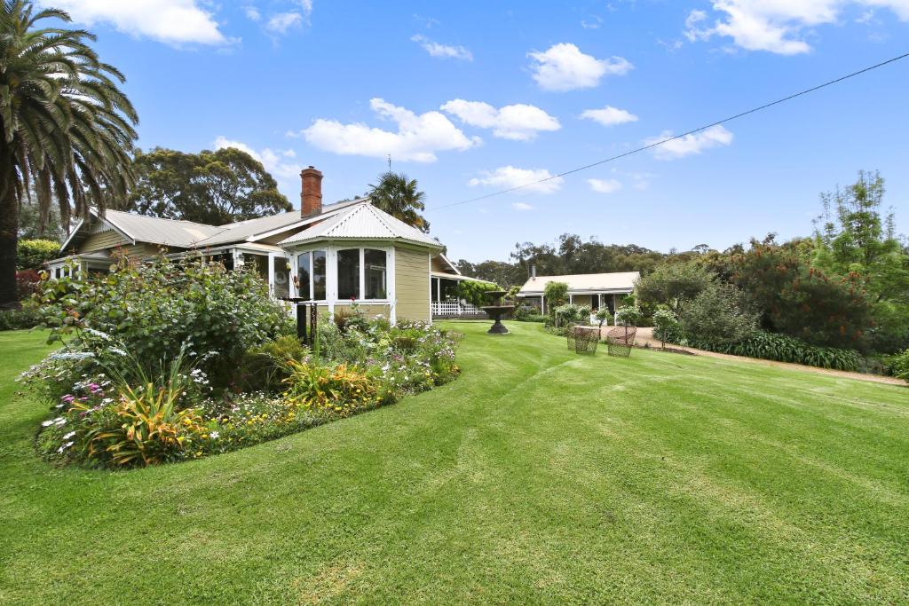 uma casa com um quintal com relva verde em Clovelly Cottage em Metung