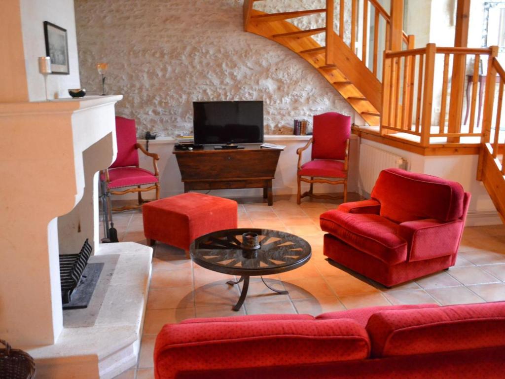sala de estar con sillas rojas y TV en Gîte Saint-Cybardeaux, 3 pièces, 4 personnes - FR-1-653-18 en Saint-Cybardeaux