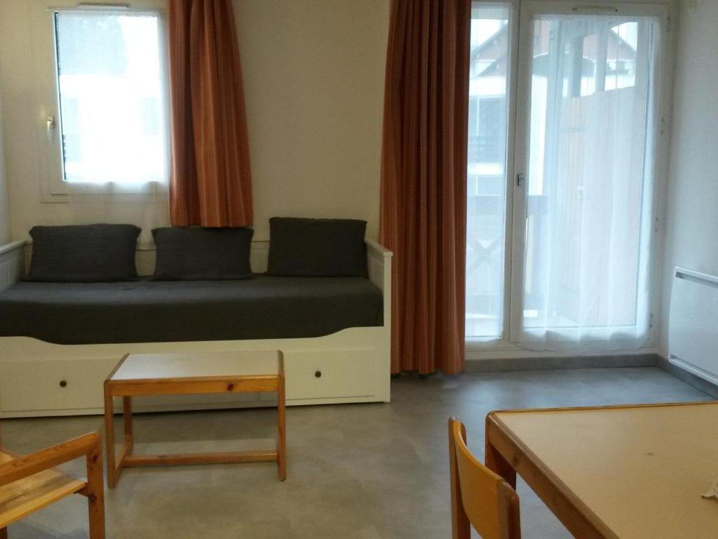 une chambre avec un lit, une table et des fenêtres dans l'établissement Studio rénové au centre de Villard-de-Lans avec coin montagne - 4 pers., balcon, WiFi, proche commerces. - FR-1-689-6, à Villard-de-Lans
