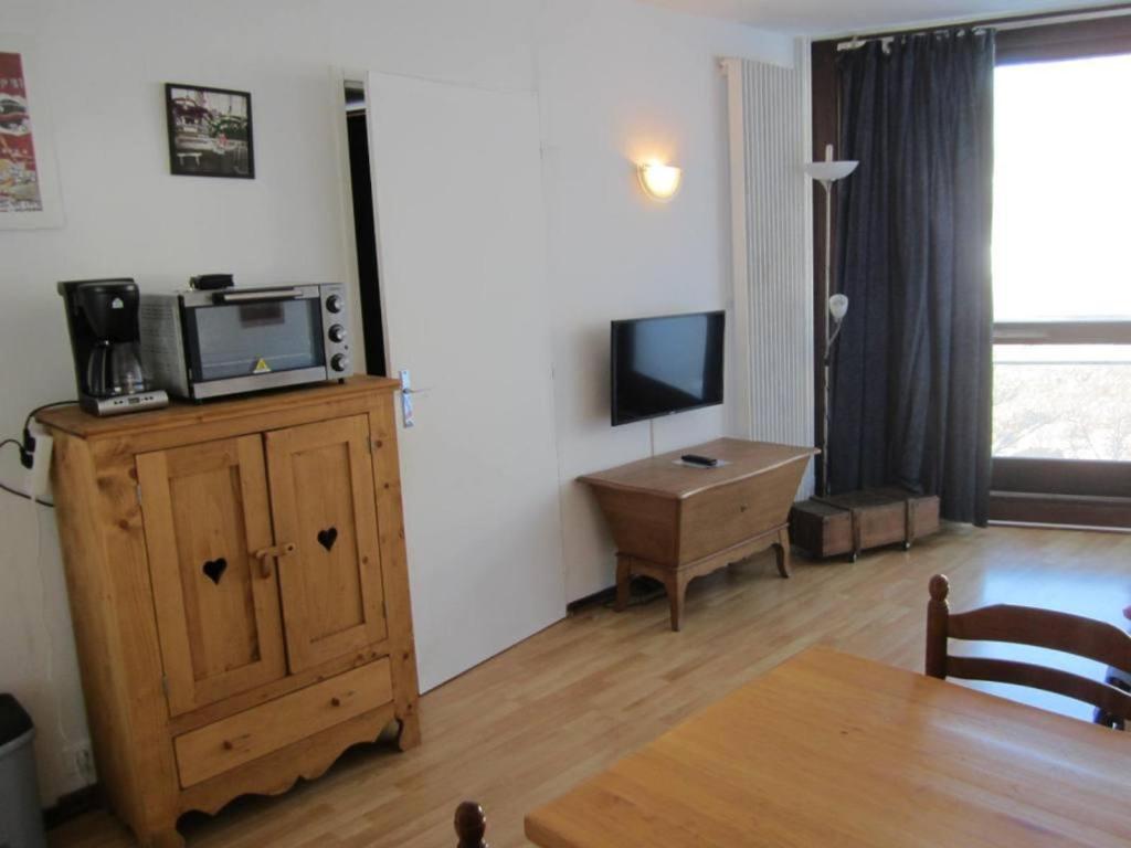 a living room with a tv and a wooden cabinet at Appartement Villard-de-Lans, 2 pièces, 6 personnes - FR-1-689-19 in Villard-de-Lans