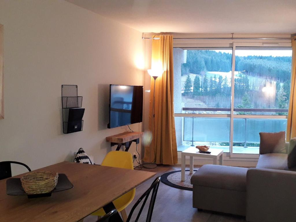 a living room with a table and a large window at Appartement Villard-de-Lans, 3 pièces, 8 personnes - FR-1-689-8 in Villard-de-Lans