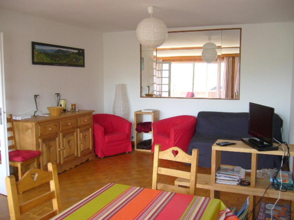 sala de estar con sofá y silla roja en Appartement Villard-de-Lans, 4 pièces, 10 personnes - FR-1-689-36, en Villard-de-Lans