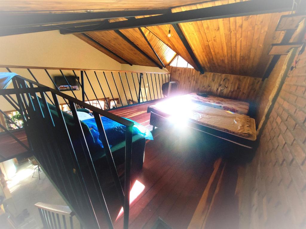 an attic room with a bed and a staircase at Chácara Engenho in Itamonte