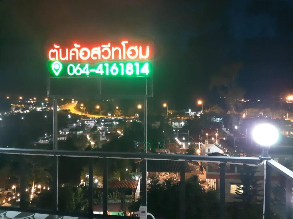 ein Neonschild mit einer Stadt in der Nacht in der Unterkunft ต้นค้อ สวีทโฮม in Khao Kho