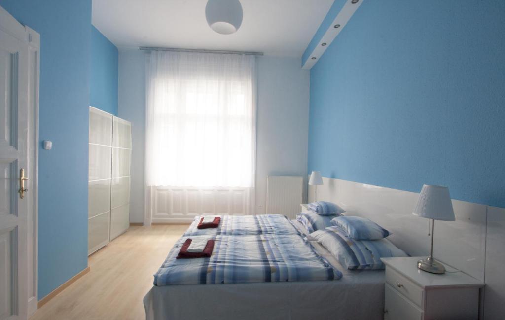 ブダペストにあるCity Centre Apartment with 3 Bathroomsの青いベッドルーム(ベッド1台、窓付)