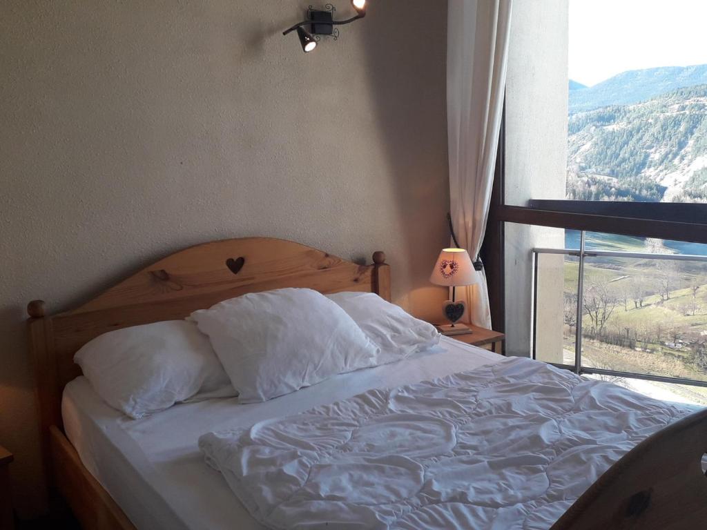 łóżko z białą pościelą i oknem z widokiem w obiekcie Très beau T3 au pied des pistes pour 6/7 personnes à Villard-de-Lans - FR-1-689-48 w mieście Villard-de-Lans