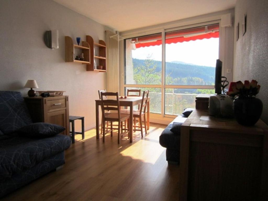 un salon avec une table et des chaises et une fenêtre dans l'établissement Studio rénové 4 personnes, pied des pistes, balcon sud, TV/DVD, cuisine équipée, parking gratuit. - FR-1-689-97, à Villard-de-Lans