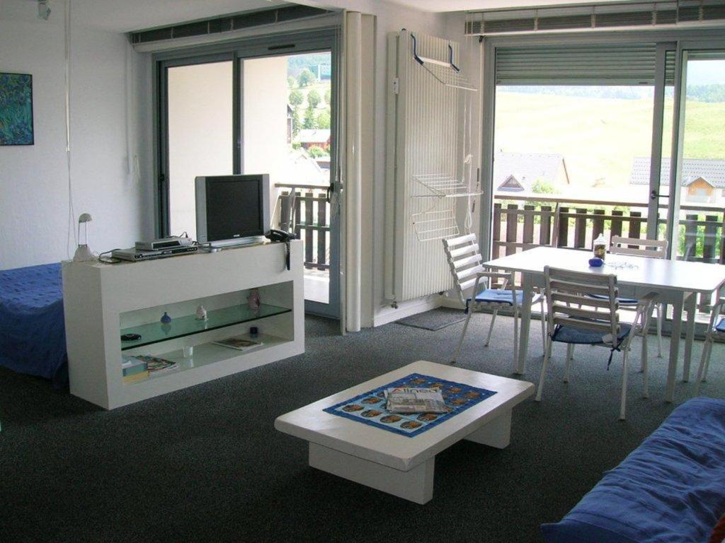 a living room with a tv and a table with chairs at Appartement Villard-de-Lans, 2 pièces, 4 personnes - FR-1-689-94 in Villard-de-Lans