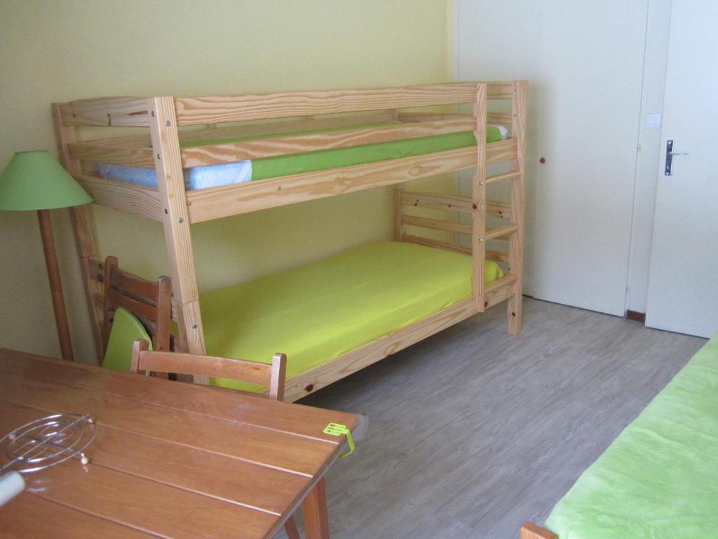 une chambre avec deux lits superposés et une table dans l'établissement Studio 4 pers, pied des pistes, proche commerces et navettes – Villard-de-Lans - FR-1-689-100, à Villard-de-Lans