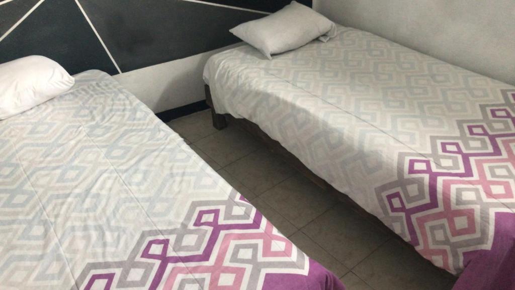 2 letti posti uno accanto all'altro in una stanza di Hotelito Ejido a Sanctórum