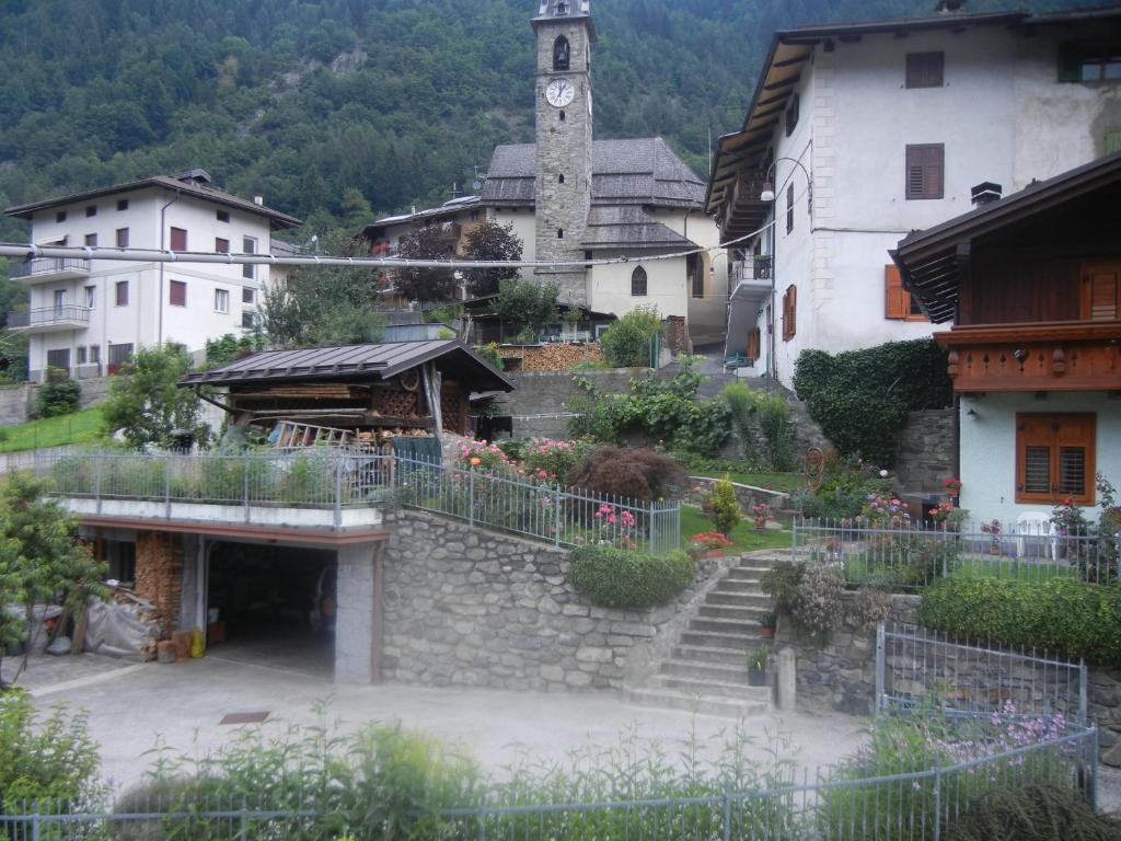 a group of buildings with a clock tower at Mansarda 2 del Capitel in Commezzadura