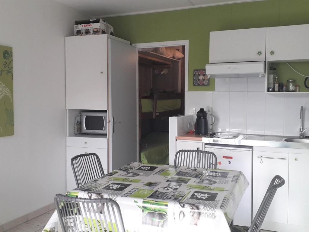 a kitchen with a table and chairs in a room at Studio Villard-de-Lans, 1 pièce, 4 personnes - FR-1-689-90 in Villard-de-Lans