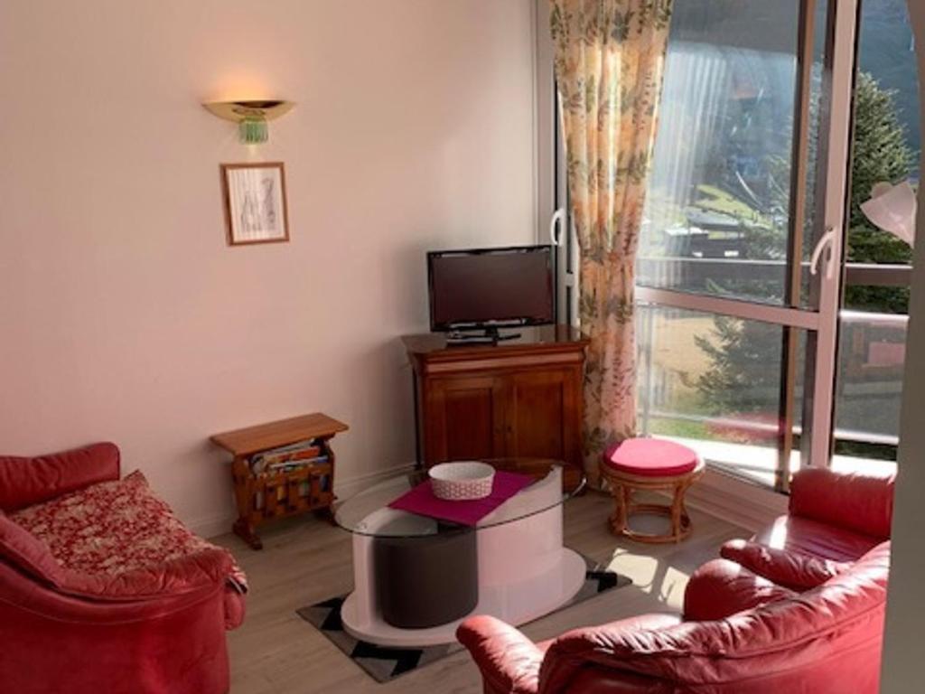 a living room with red chairs and a television at Appartement Villard-de-Lans, 3 pièces, 6 personnes - FR-1-689-108 in Villard-de-Lans