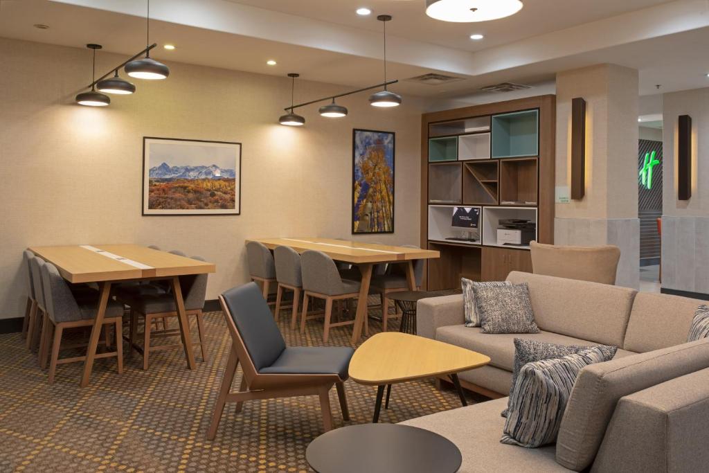 a living room with a couch and tables and chairs at Holiday Inn & Suites Durango Downtown by IHG in Durango