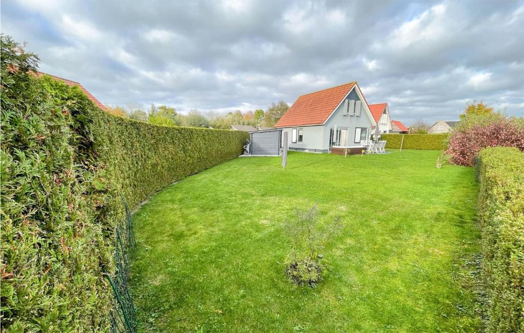 a fence in front of a yard with a house at 3 Bedroom Cozy Home In Tzummarum in Tzummarum
